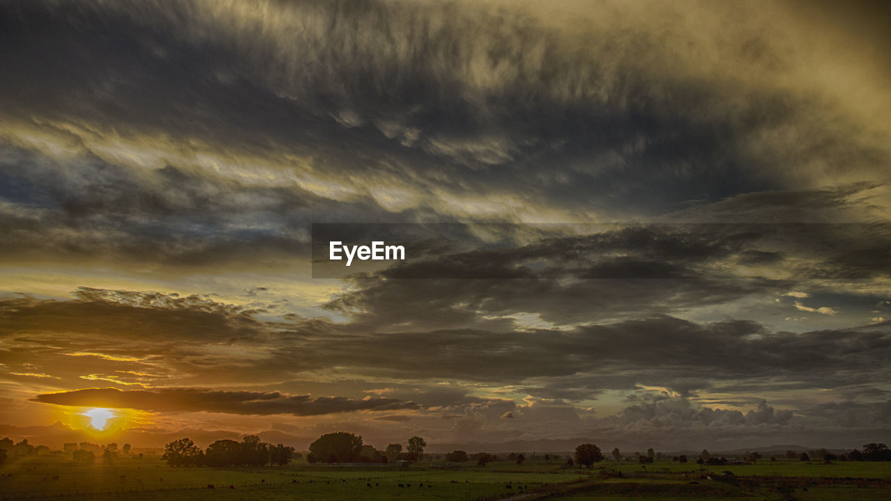 SCENIC VIEW OF SUNSET OVER FIELD