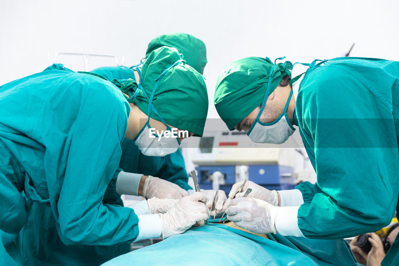 Doctors are treating patients in operating rooms. the surgeon team is working in the operating room.