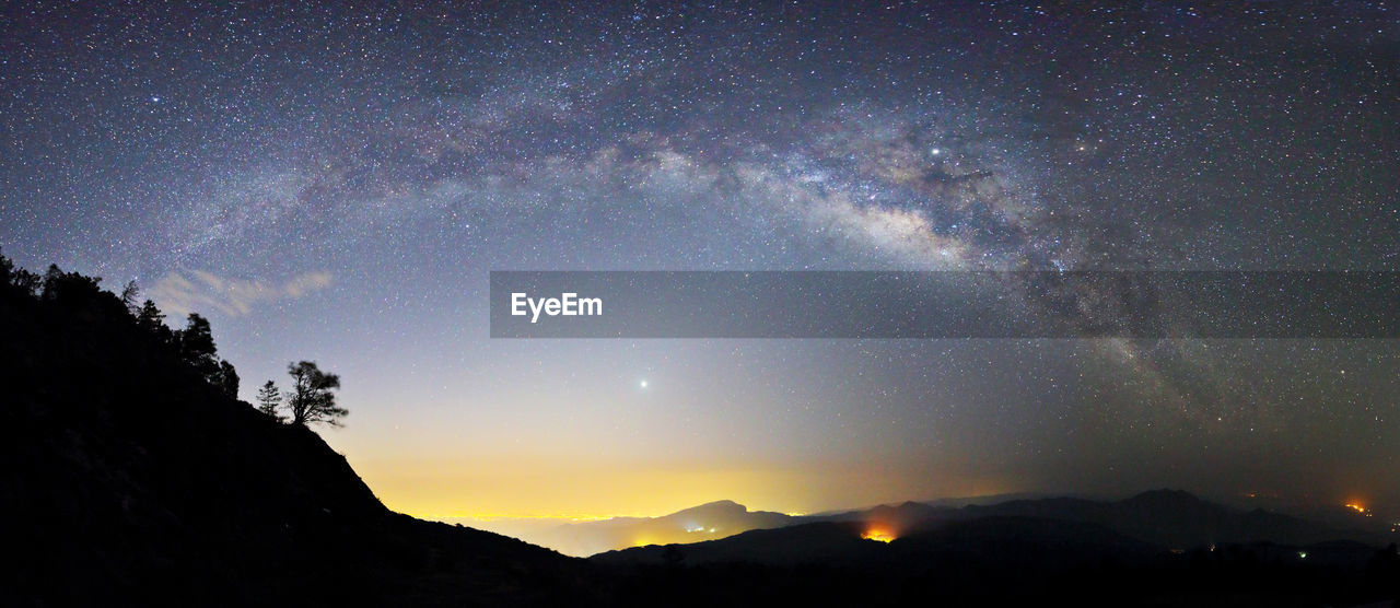 SCENIC VIEW OF SILHOUETTE MOUNTAIN AGAINST STAR FIELD