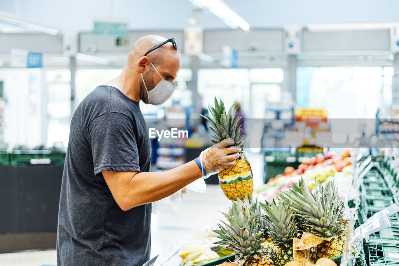 Man buying fresh fruit in supermarket