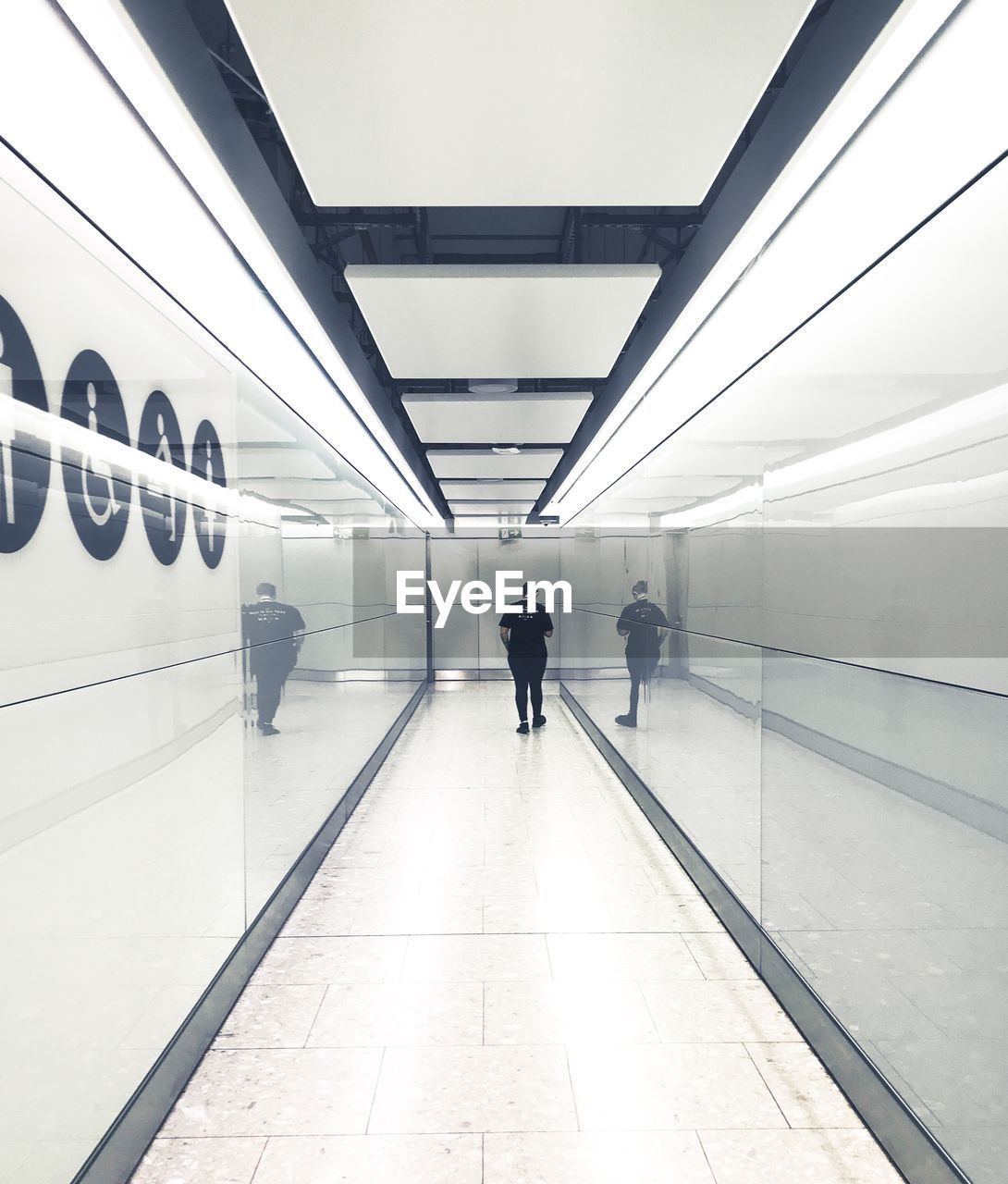 REAR VIEW OF MAN WALKING ON SUBWAY