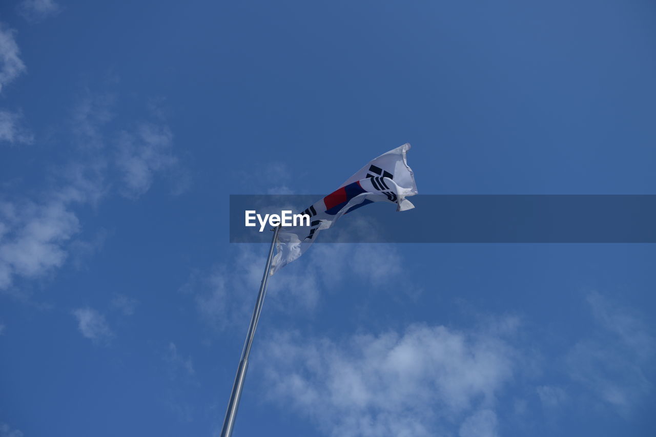 LOW ANGLE VIEW OF FLAG FLYING AGAINST SKY