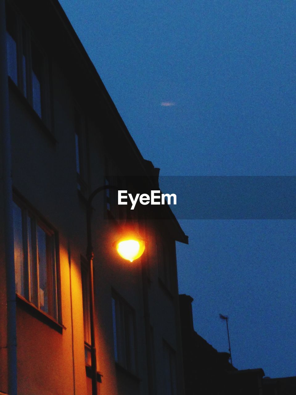 LOW ANGLE VIEW OF ILLUMINATED BUILDING AGAINST SKY