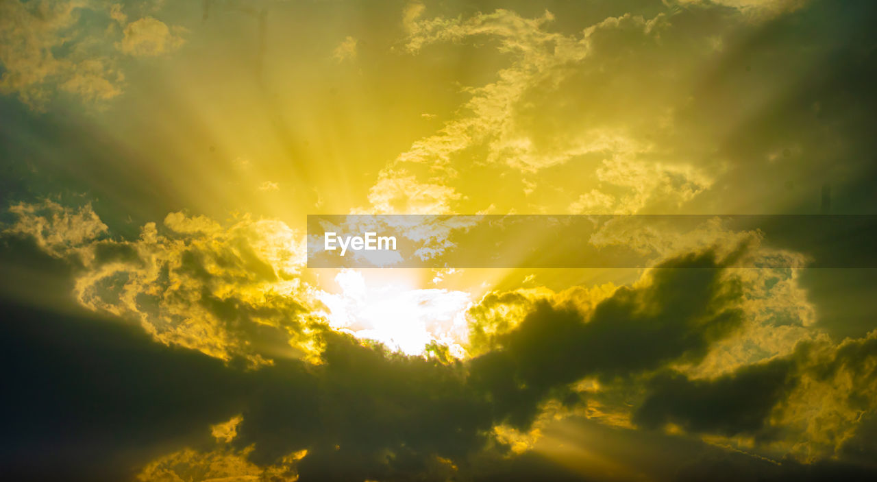 sky, sunlight, cloud, sun, beauty in nature, dramatic sky, sunbeam, nature, sunset, environment, yellow, scenics - nature, cloudscape, light, backgrounds, light - natural phenomenon, tranquility, no people, idyllic, vibrant color, outdoors, back lit, awe, summer, gold, tranquil scene, moody sky, landscape, bright, horizon, multi colored, religion, atmospheric mood, afterglow, twilight, atmosphere, spirituality, low angle view, glowing, orange color, astronomical object, lens flare, daytime