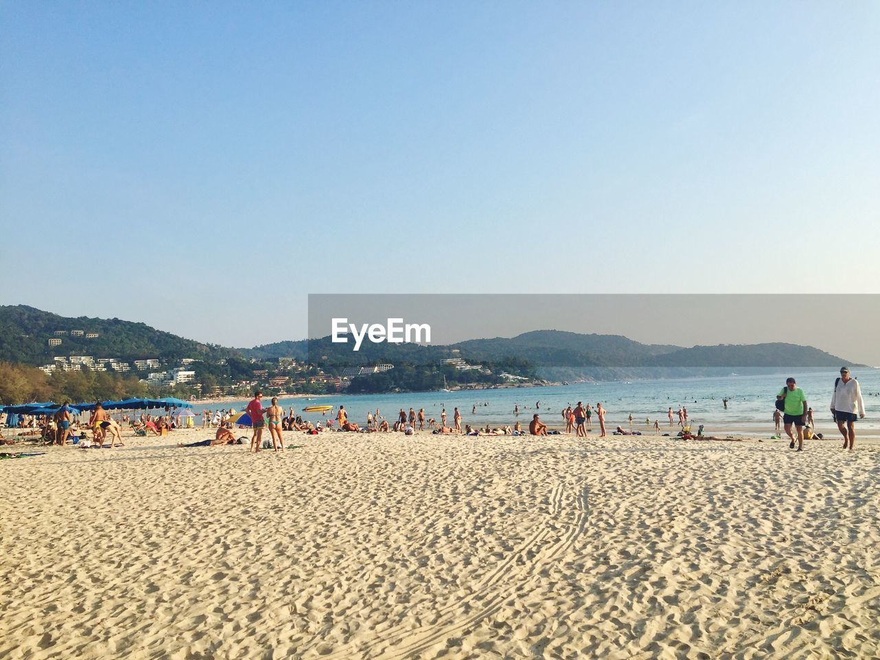 PEOPLE AT BEACH AGAINST CLEAR BLUE SKY