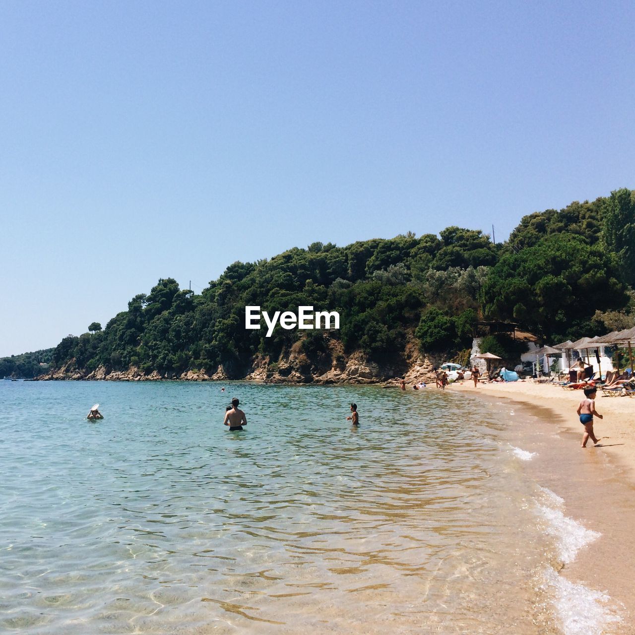 PEOPLE IN SEA AGAINST CLEAR BLUE SKY