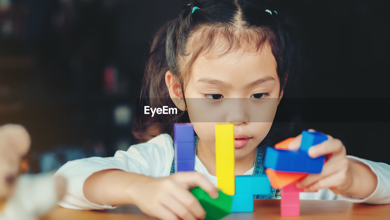 Close-up of cute girl playing with toy on table