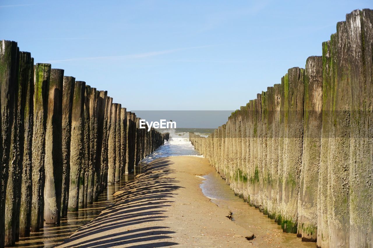 PANORAMIC VIEW OF WOODEN POSTS ON BEACH