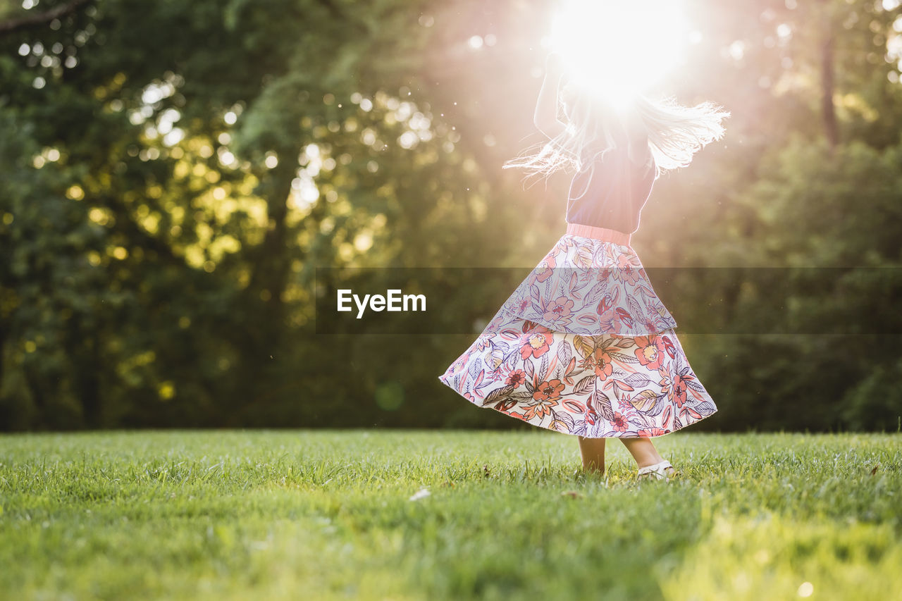 REAR VIEW OF GIRL WITH UMBRELLA ON TREE