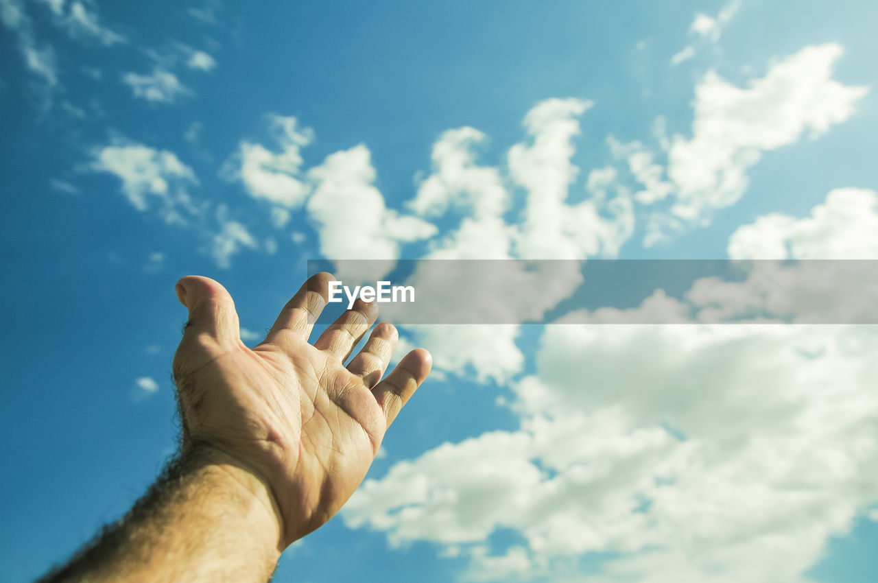 View of human hand against sky