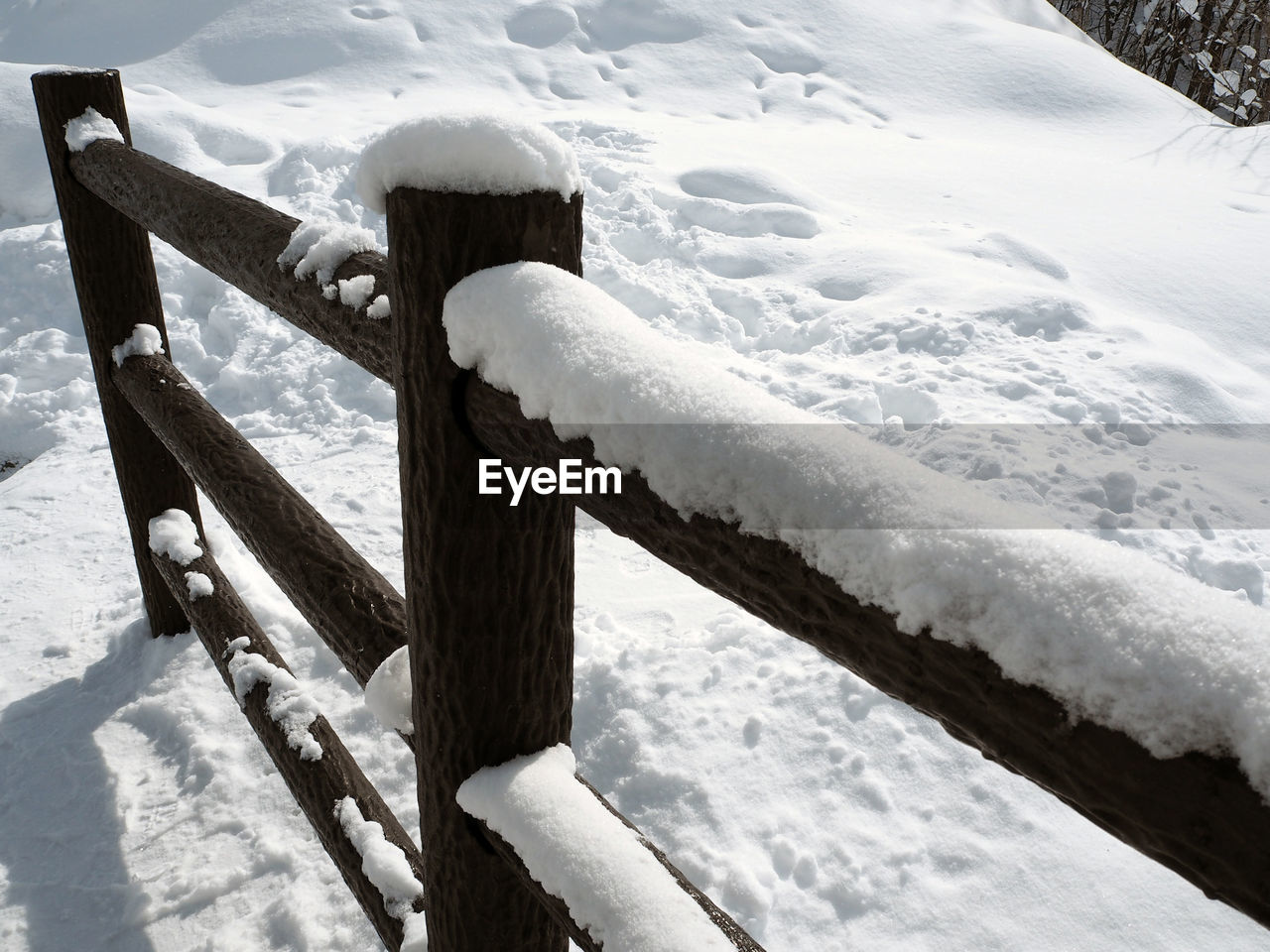 HIGH ANGLE VIEW OF SNOW COVERED BENCH BY FROZEN WATER