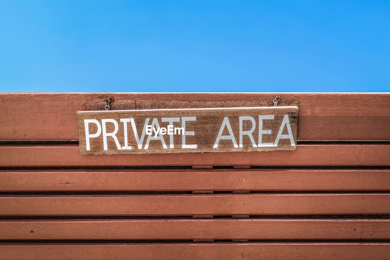 LOW ANGLE VIEW OF SIGN AGAINST BLUE SKY