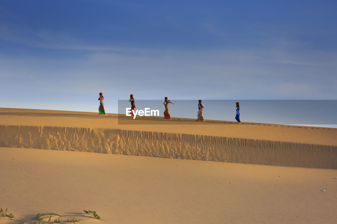 MEN ON DESERT AGAINST SKY