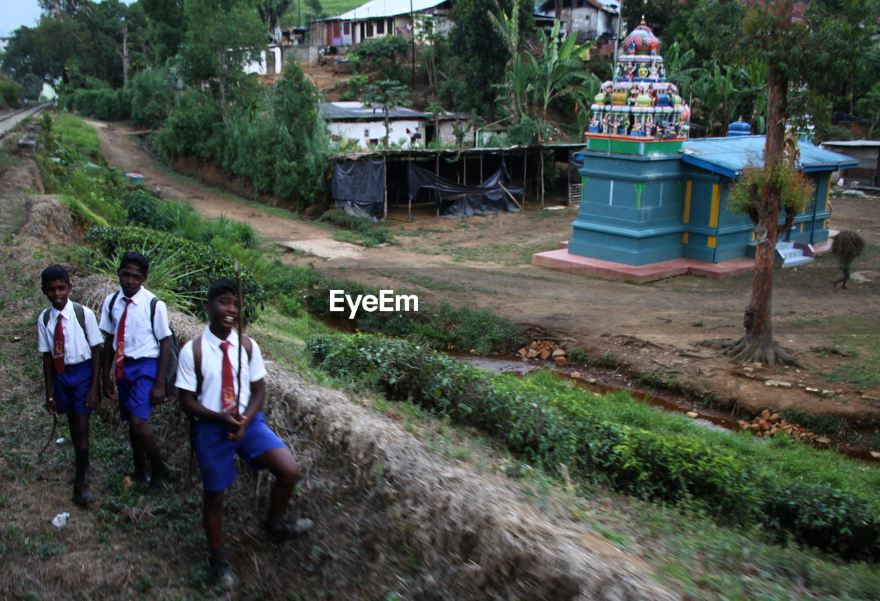 REAR VIEW OF PEOPLE WALKING ON MOUNTAIN