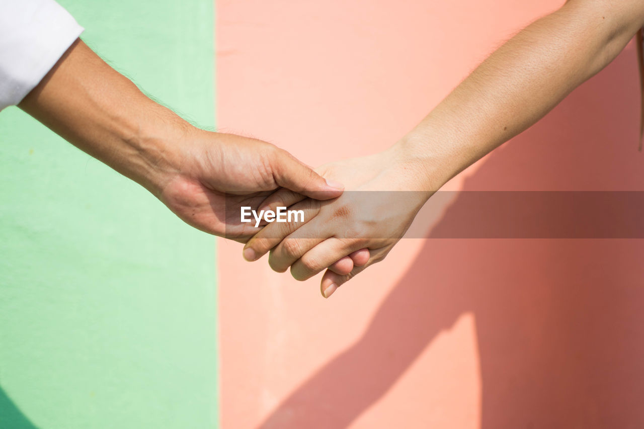 Cropped hand against wall