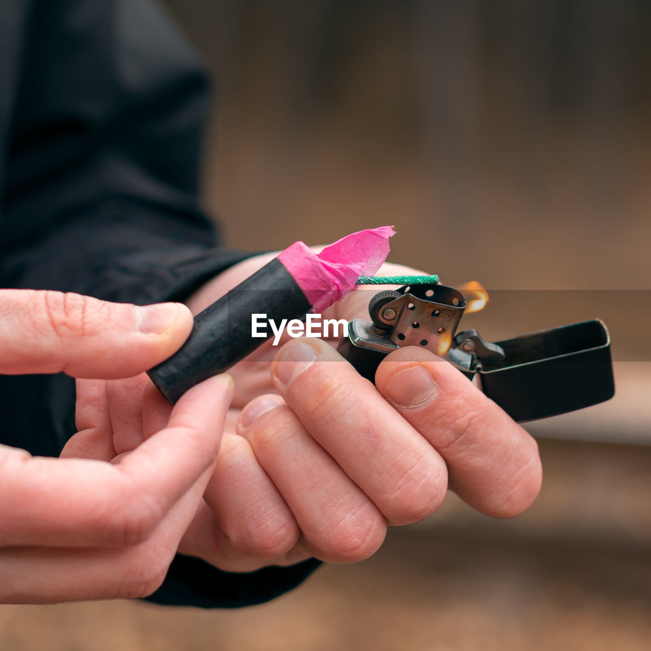 Close-up of man igniting firecracker outdoors