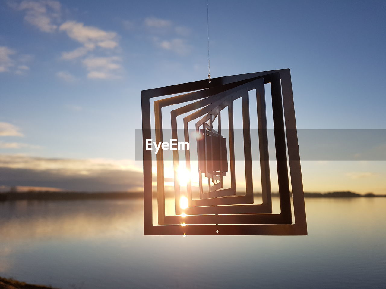 GAZEBO IN LAKE AGAINST SKY AT SUNSET