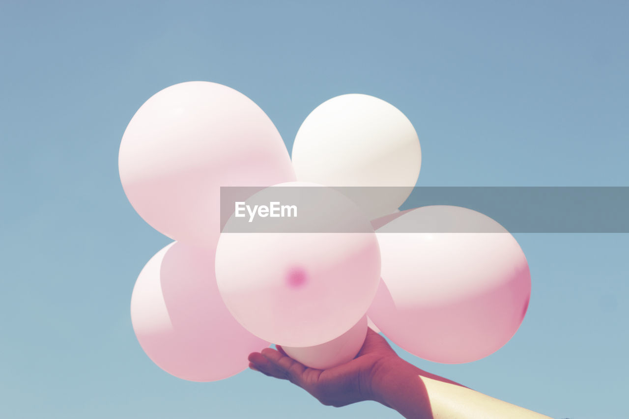 Low angle view of balloons against blue sky