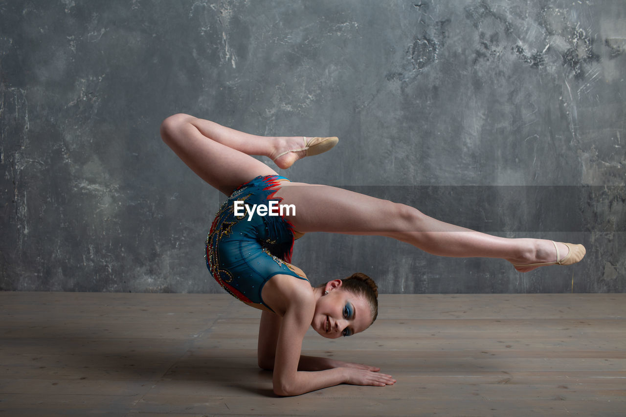 Woman lying on floor against wall