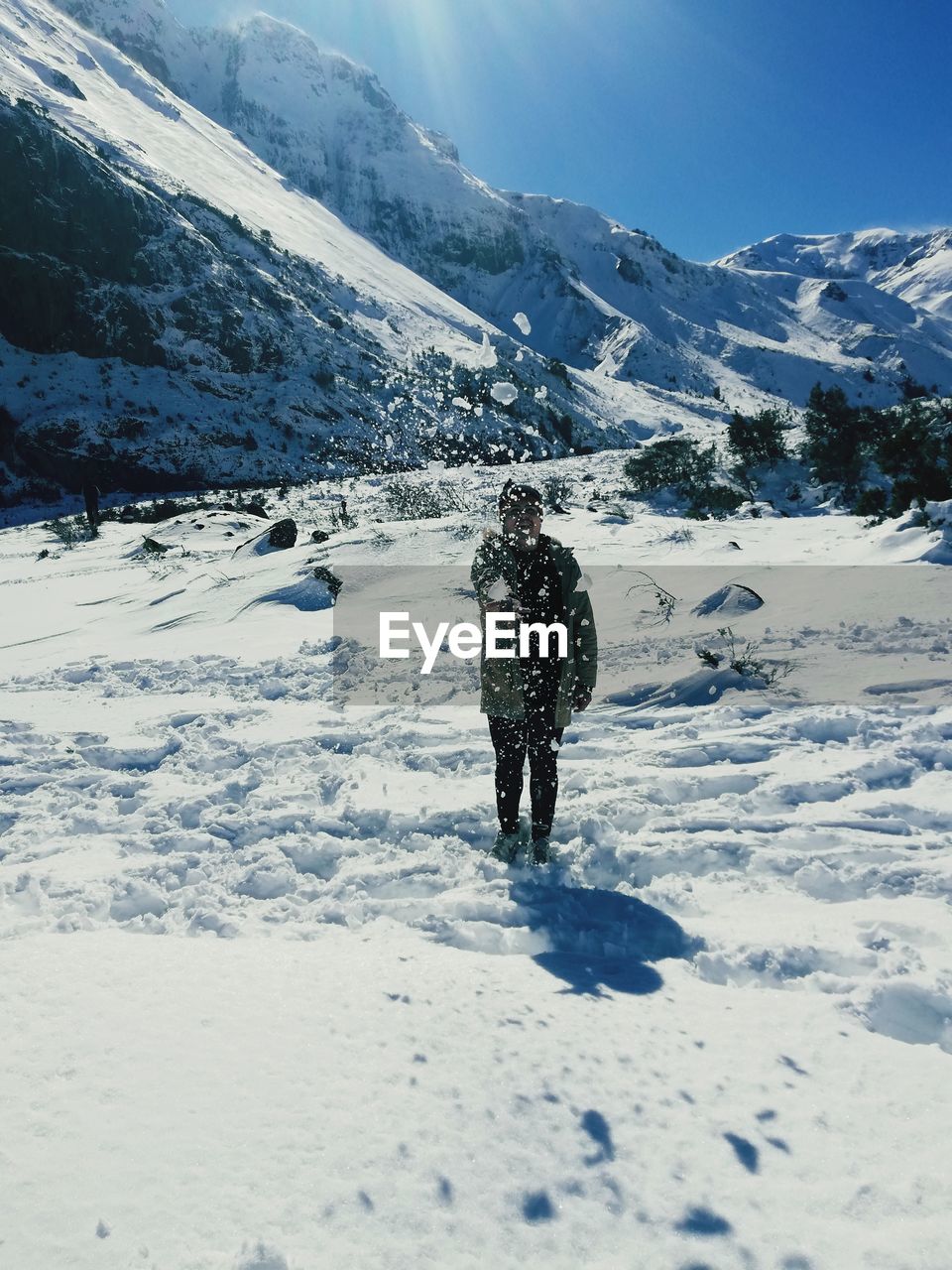 REAR VIEW OF PERSON ON SNOW COVERED MOUNTAIN