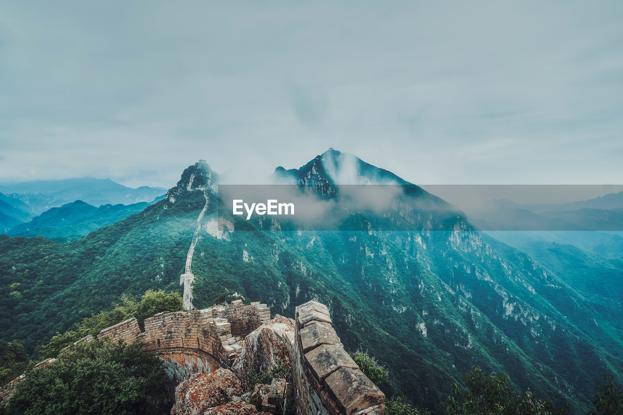 Scenic view of great wall of china amidst mountains against sky