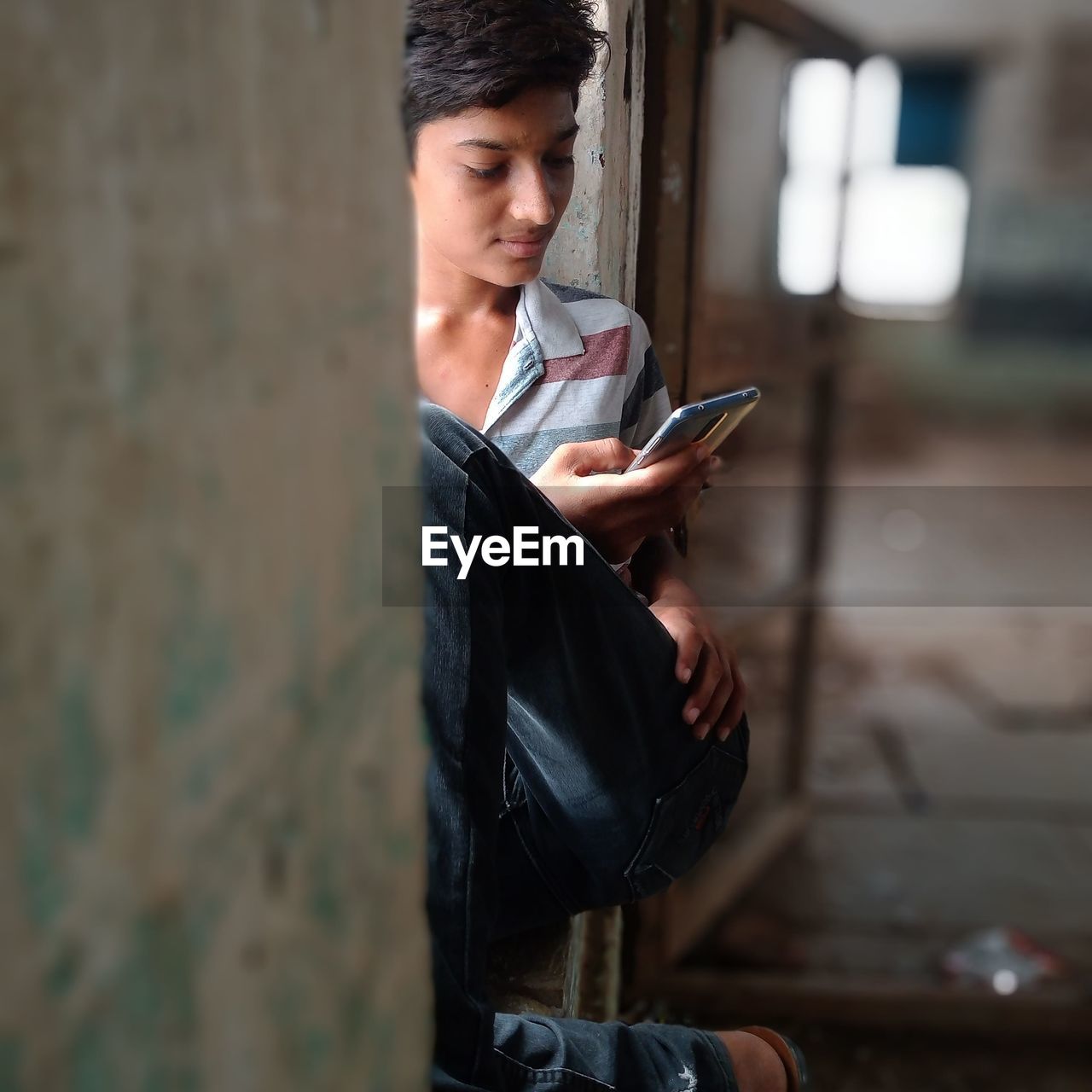 Boy holding mobile while sitting