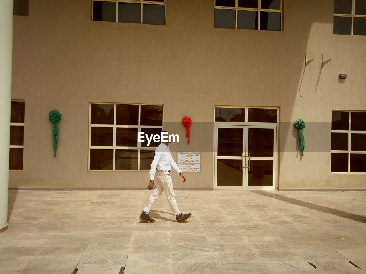 WOMAN IN FRONT OF BUILDING WITH UMBRELLA