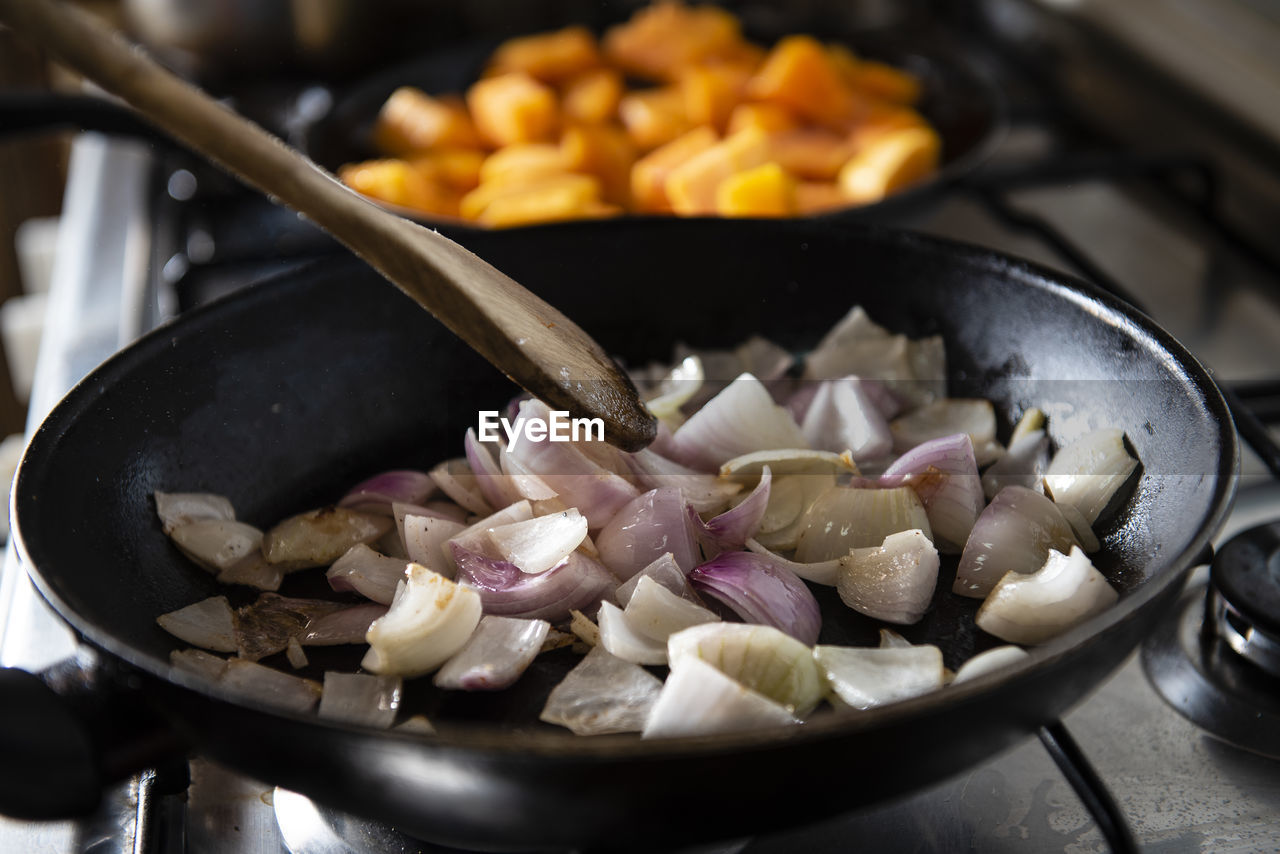 Woman cooking a vegetable soup with pumpkin, potato and onion. s