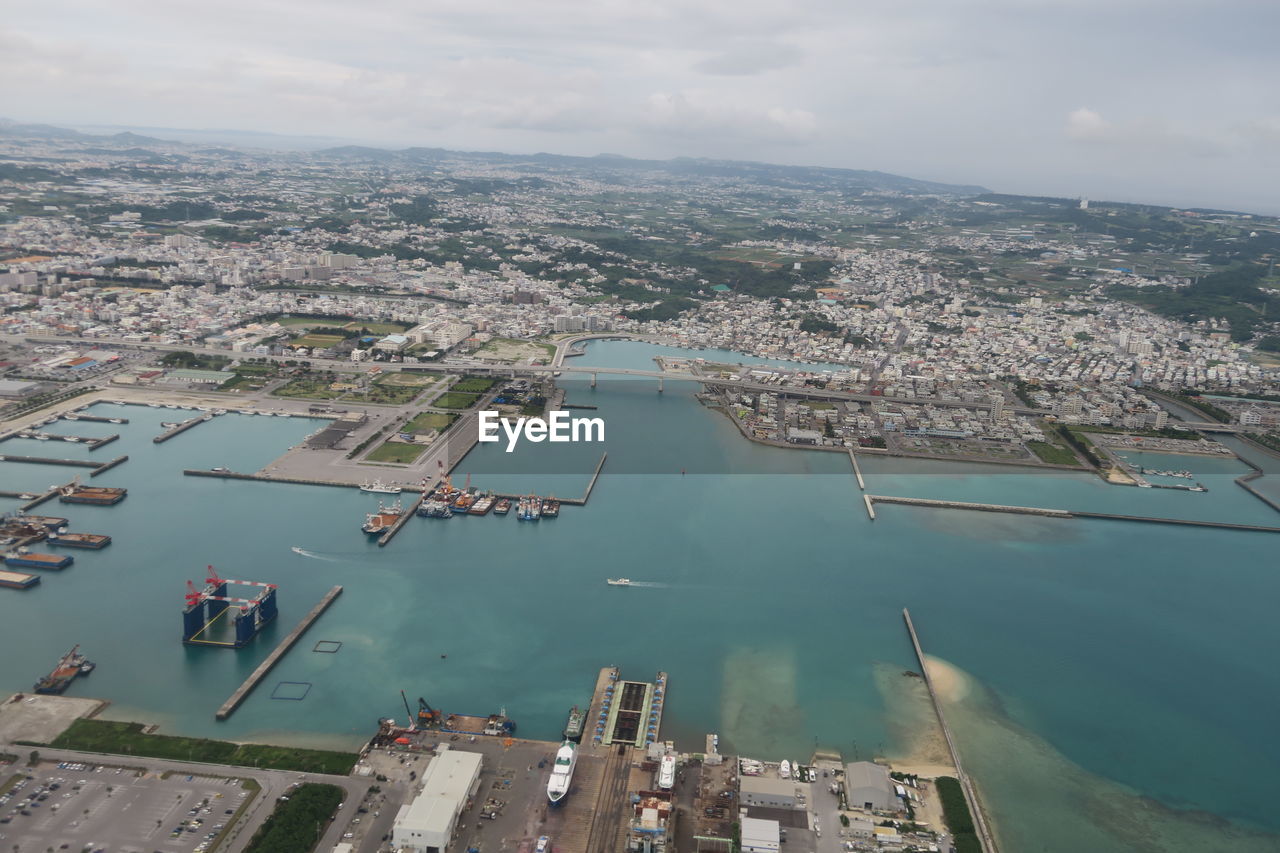 Aerial view of river by buildings in city against sky