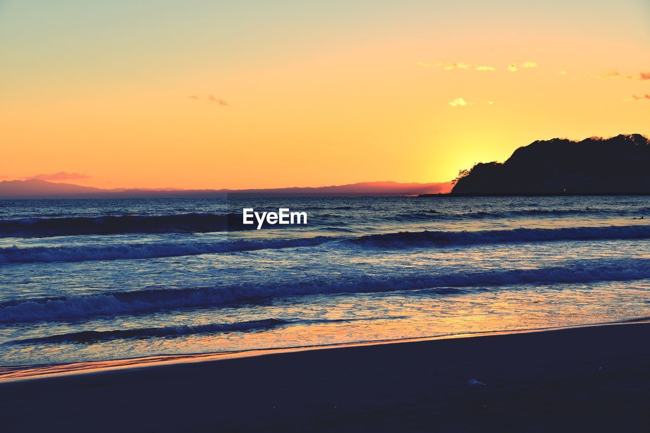 SCENIC VIEW OF BEACH AGAINST SKY DURING SUNSET