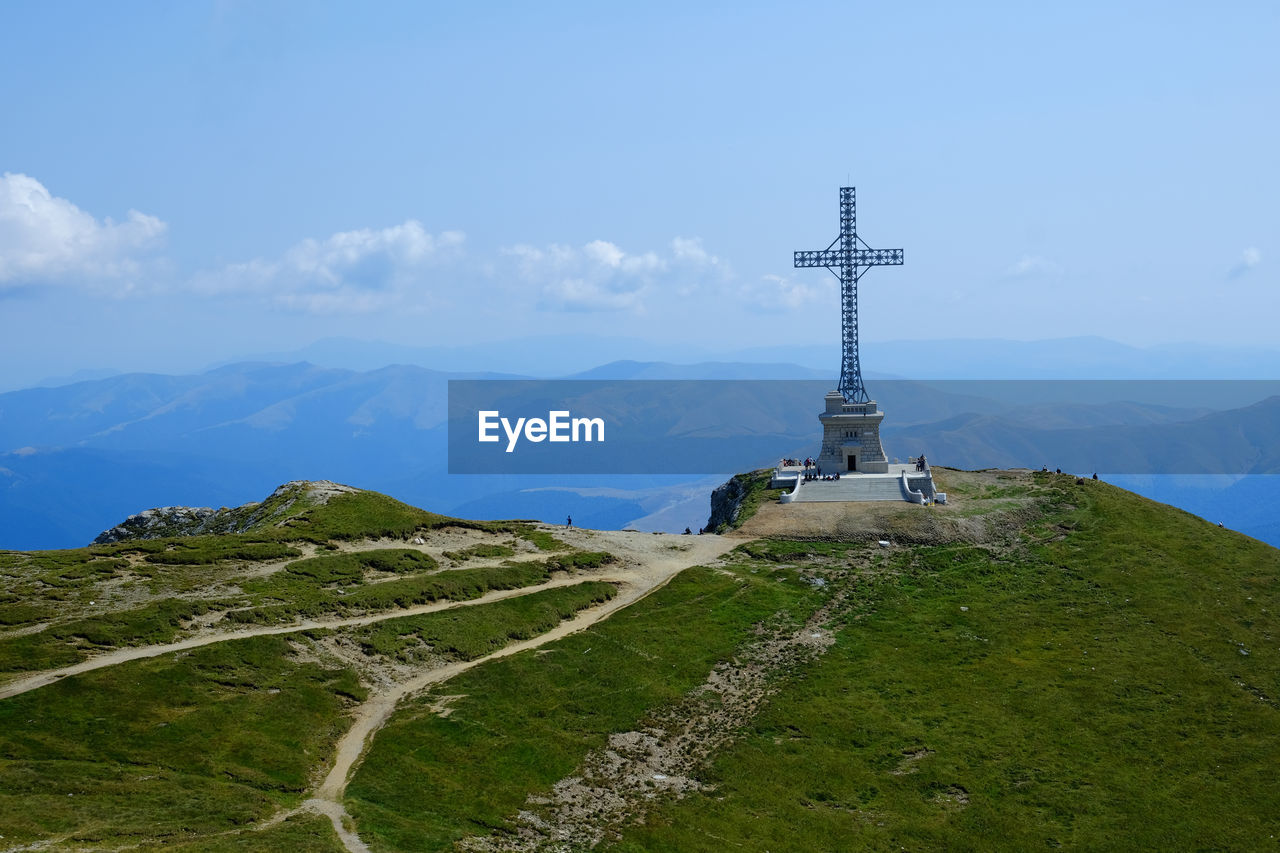 Cross on mountain against sky