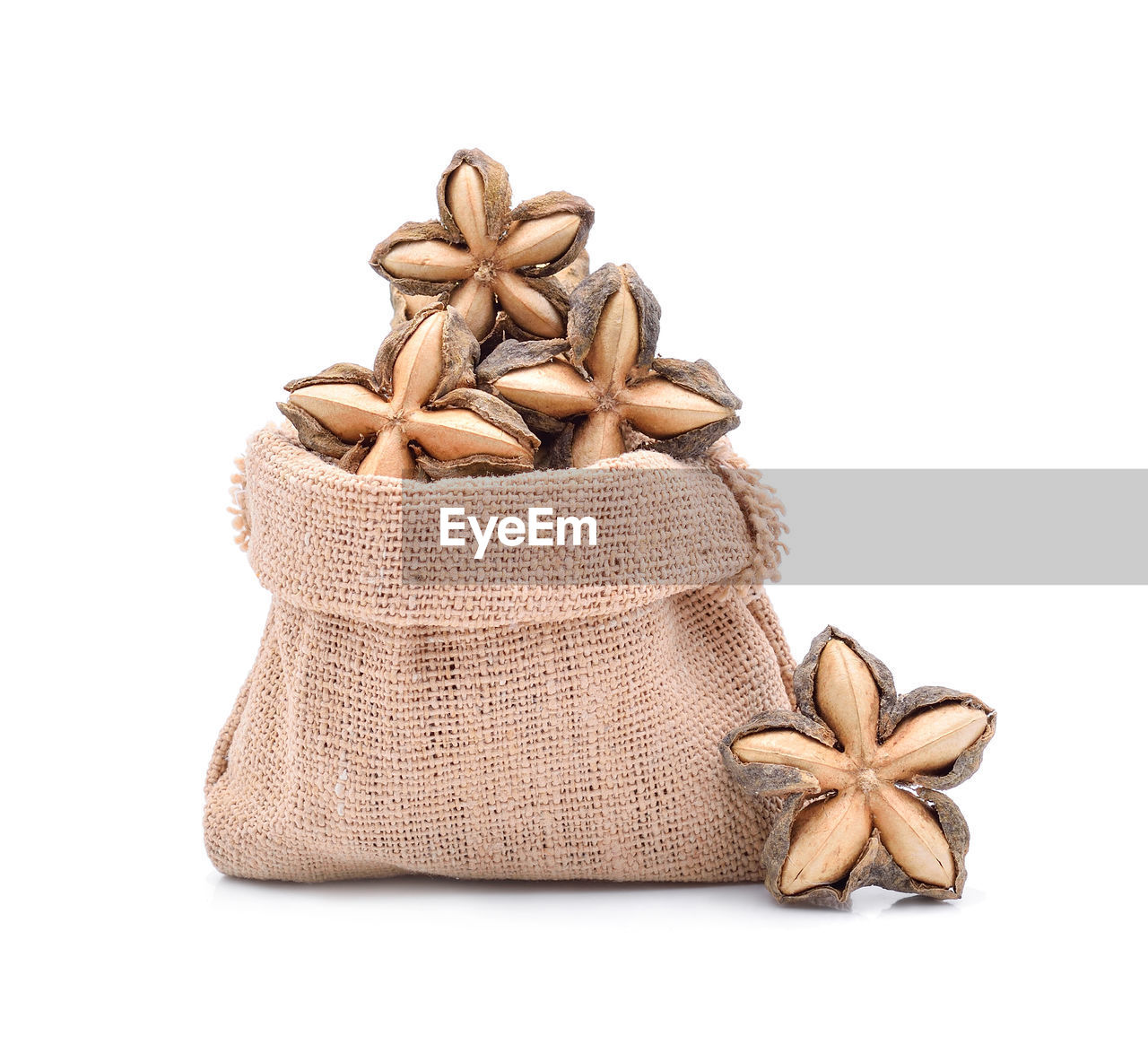 Close-up of star anise in sack against white background