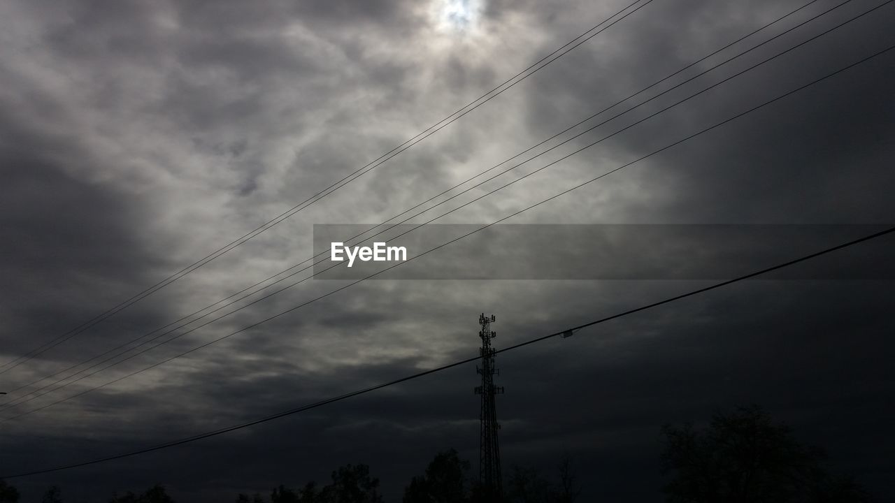 LOW ANGLE VIEW OF BIRDS FLYING OVER POWER LINES