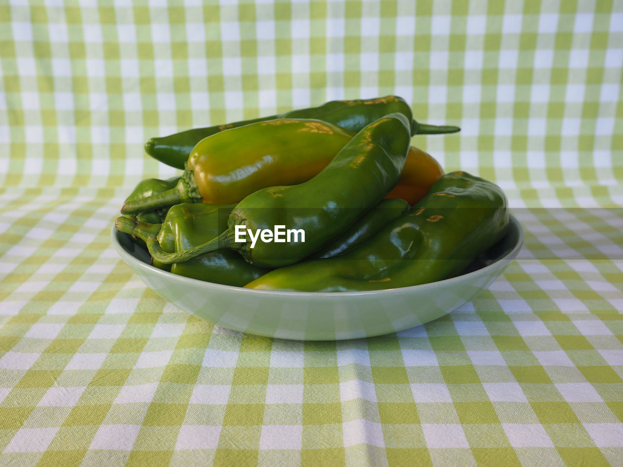 food, food and drink, checked pattern, tablecloth, produce, vegetable, healthy eating, freshness, green, wellbeing, indoors, no people, fruit, bell peppers and chili peppers, pattern, plant, high angle view, dish, studio shot, chili pepper, table, still life, textile, bell pepper