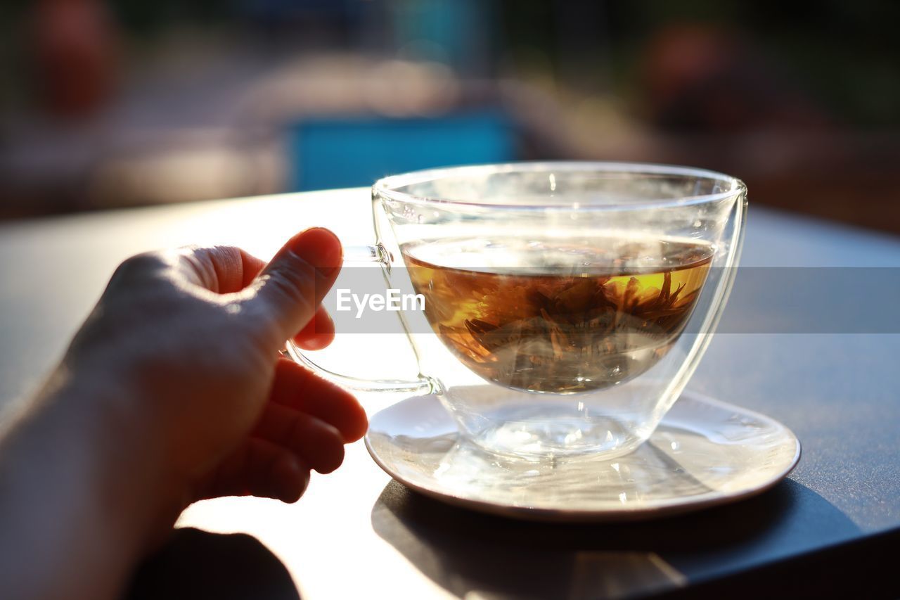 CLOSE-UP OF PERSON HAND HOLDING DRINK