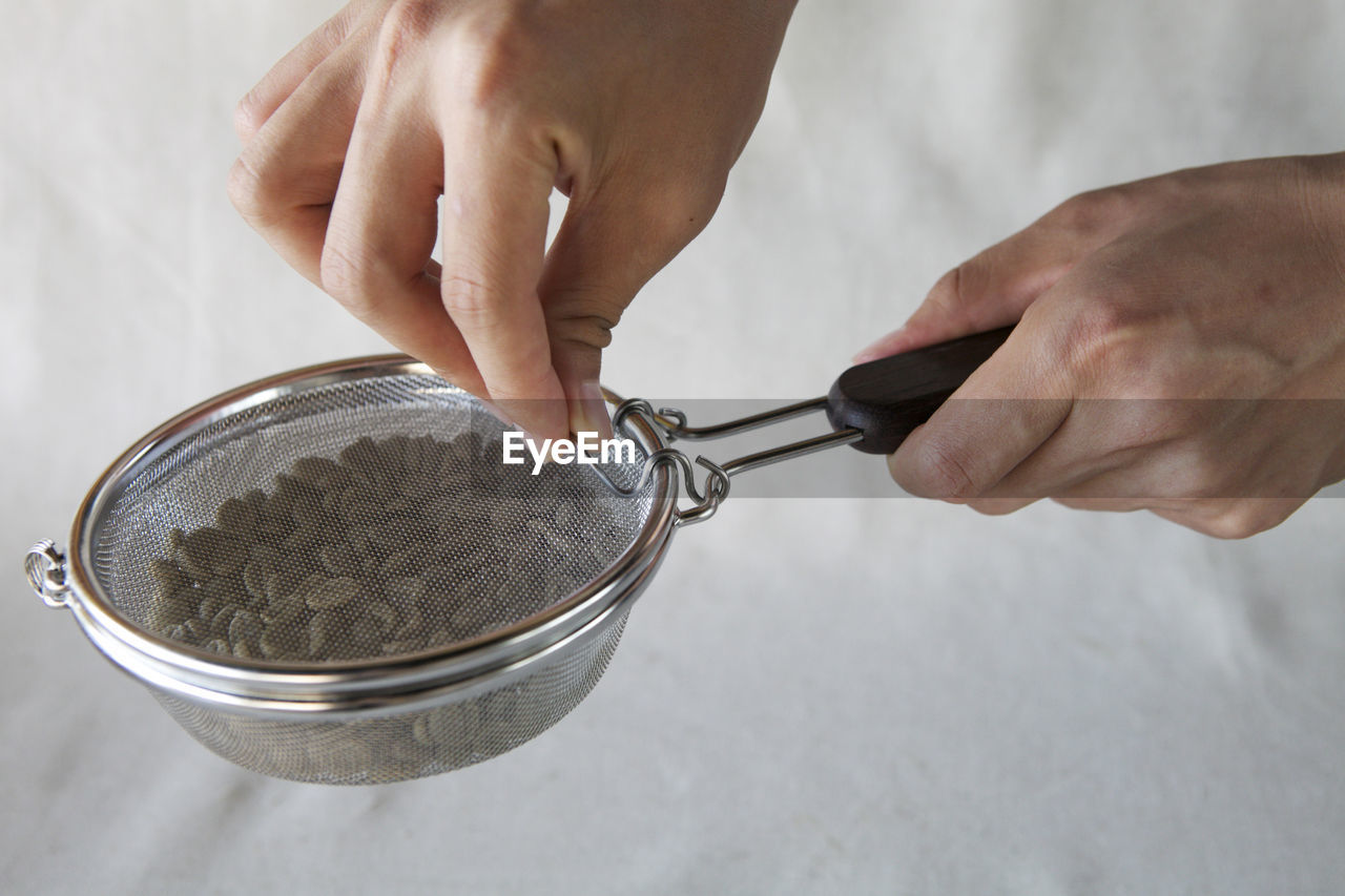 Cropped image of hands holding coffee bean roaster