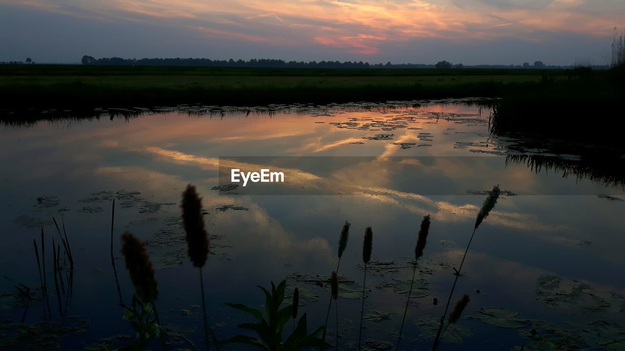 Scenic view of lake against sky during sunset