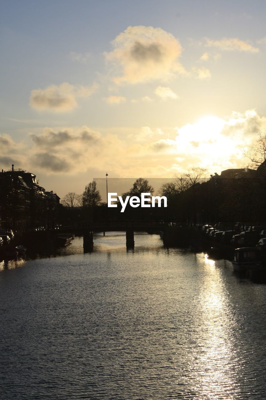 Scenic view of river against sky at sunset