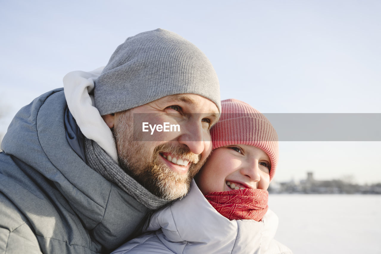 Happy father and daughter wearing knit hats in winter
