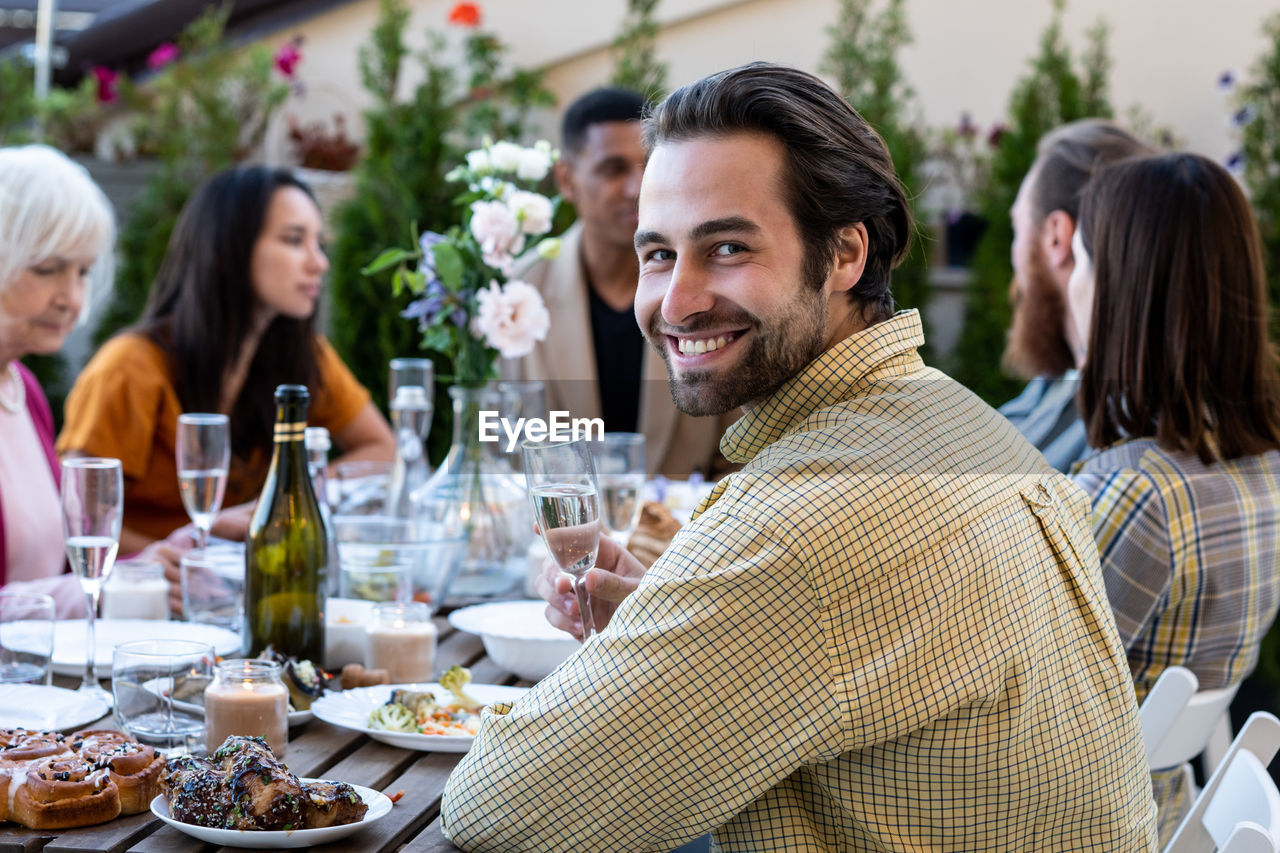 Portrait of smiling friends sitting at restaurant