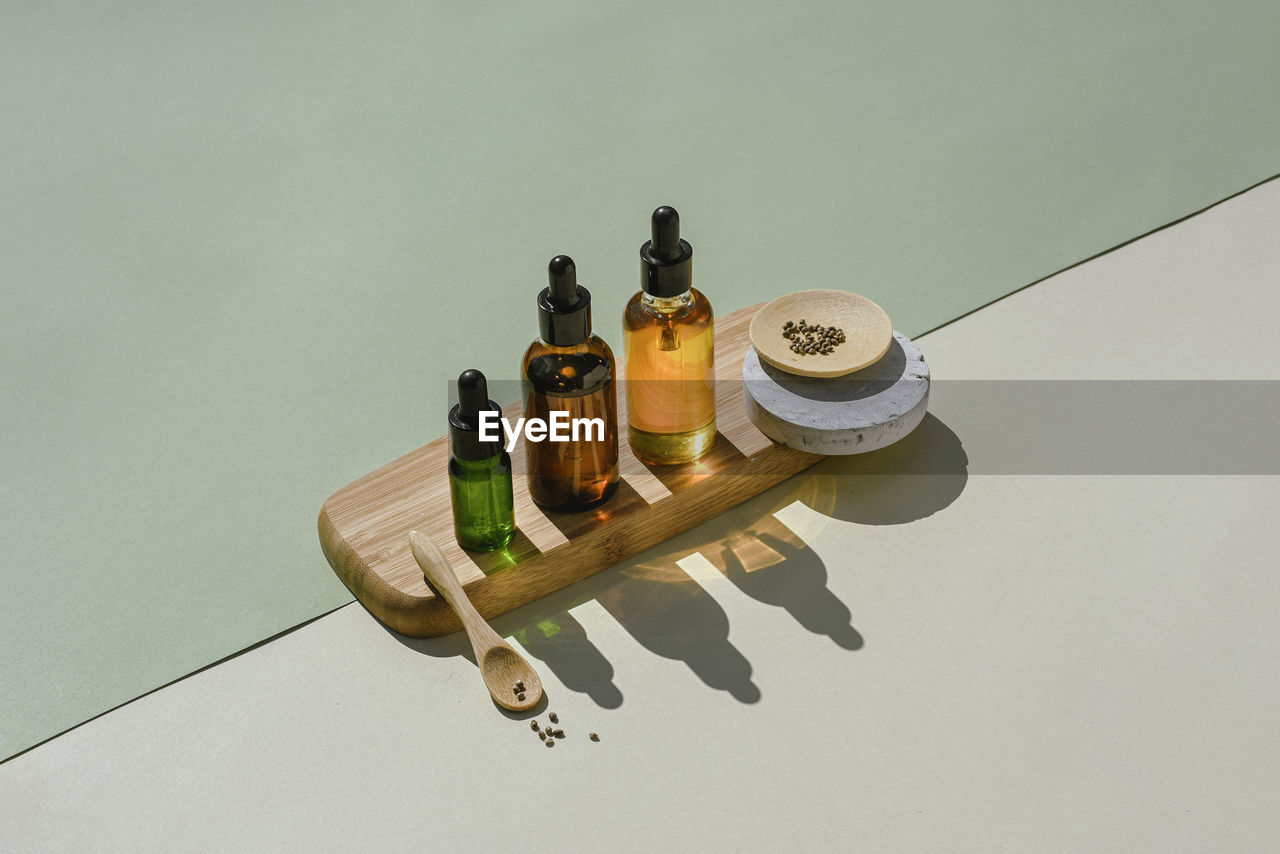 Cbd oil in bottle and cannabis bush, hemp, white podium