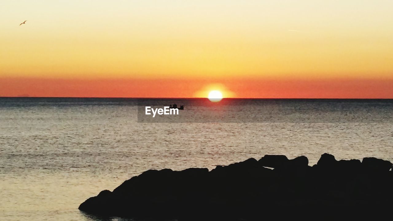 SCENIC VIEW OF SEA AGAINST SKY AT SUNSET