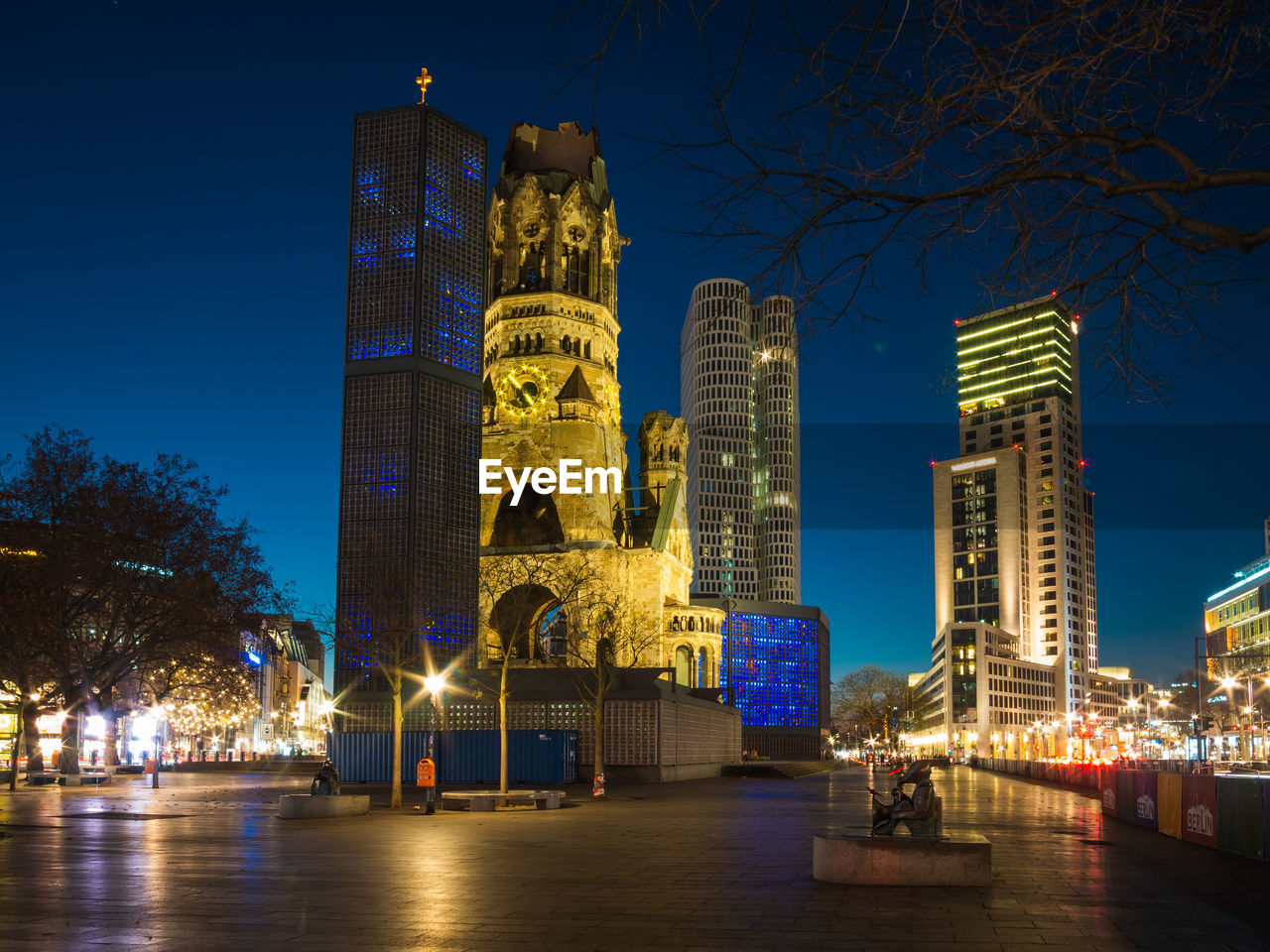 LOW ANGLE VIEW OF ILLUMINATED BUILDINGS AGAINST BLUE SKY AT NIGHT