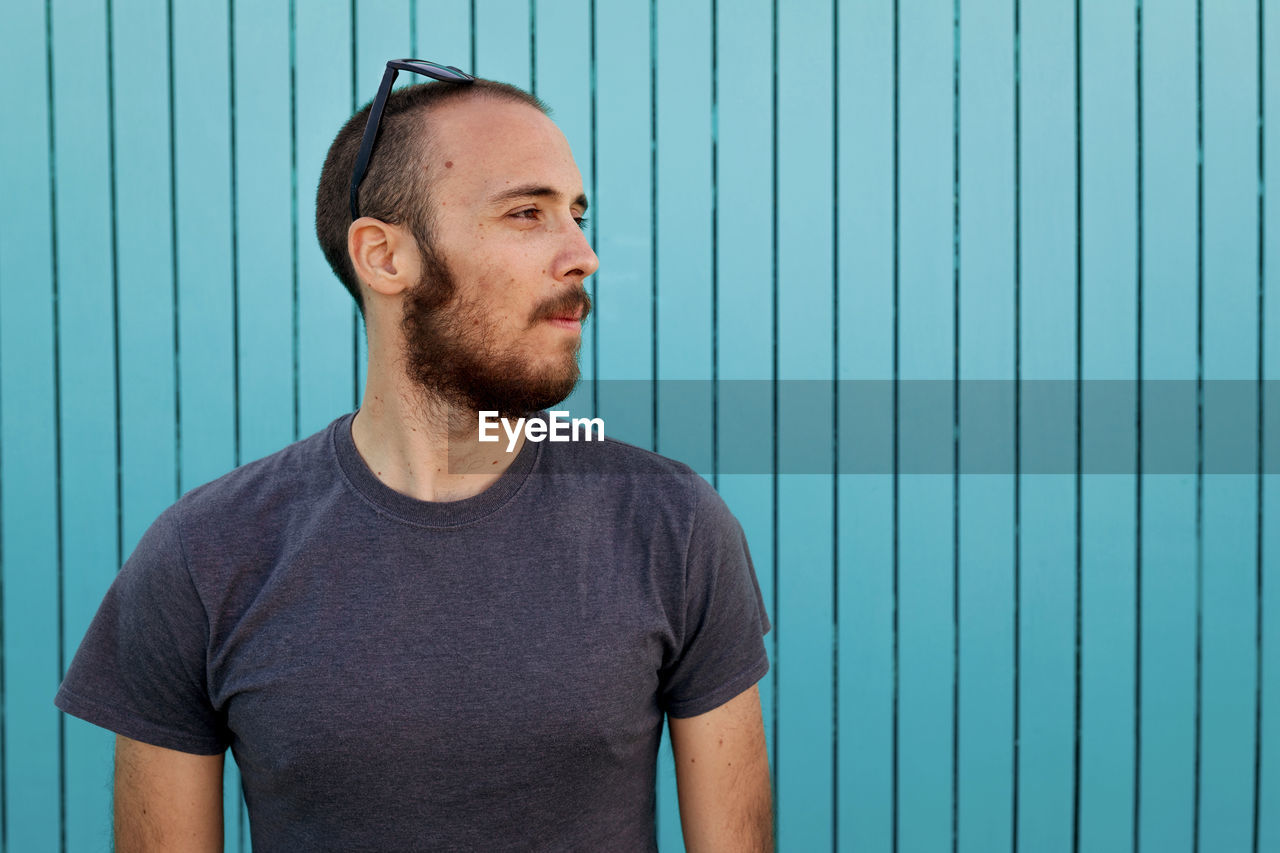 Portrait of man standing against wall