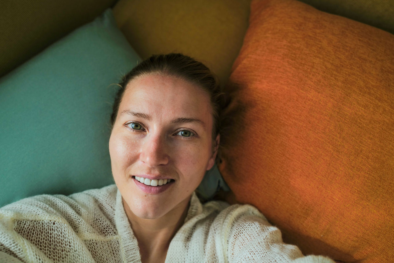 Woman relaxing on the colorful pillows smiling