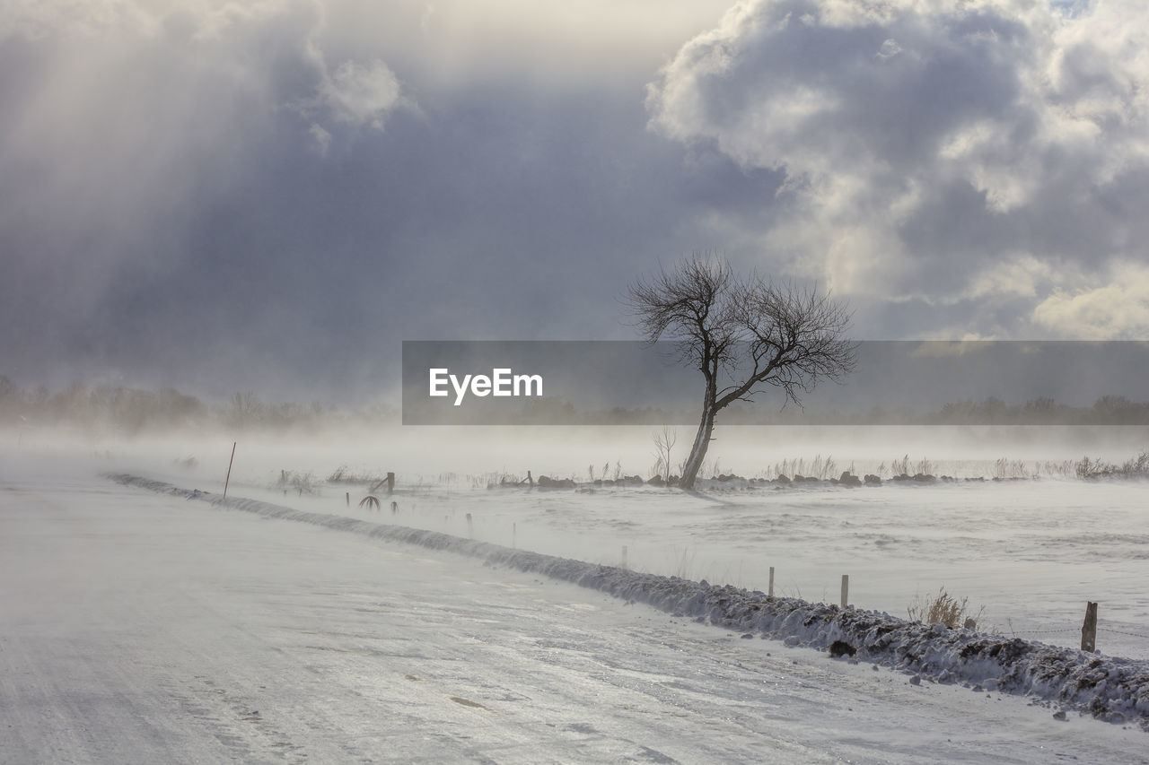 Scenic view of snow covered field against sky