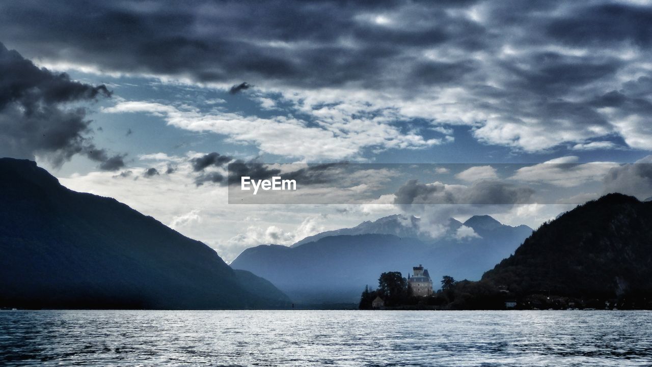 SCENIC VIEW OF SEA AGAINST MOUNTAINS