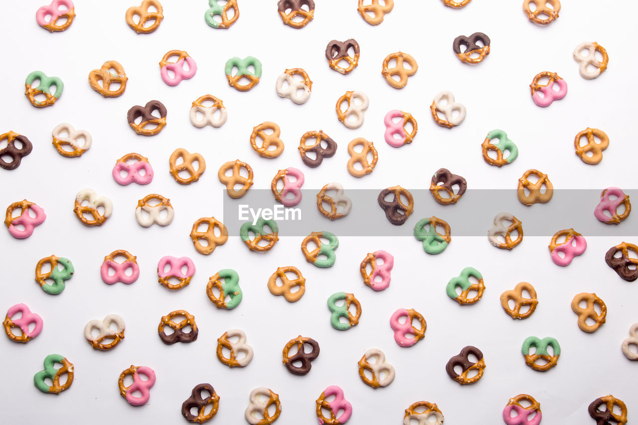 Directly above shot of colorful pretzels on white background
