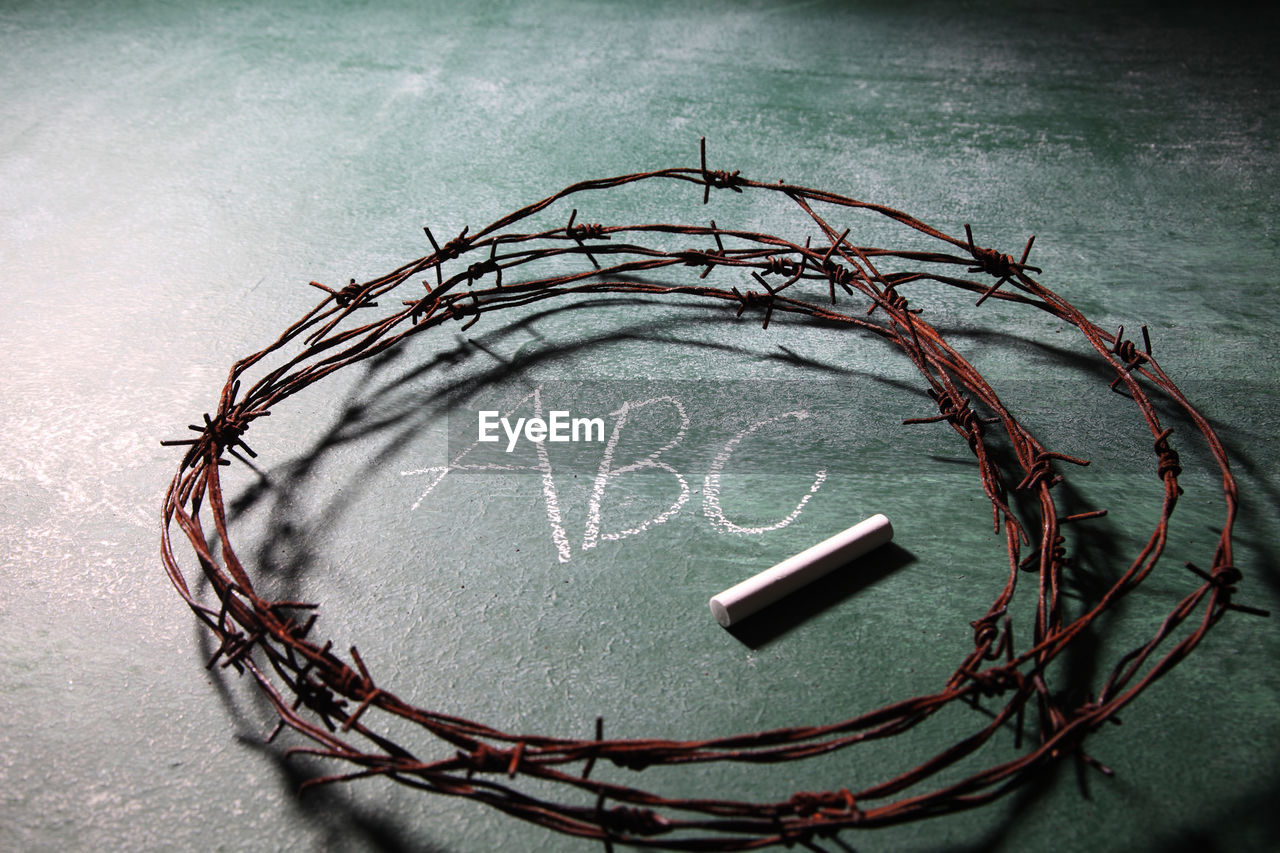 Close-up of rusty barbed wire with chalk on blackboard