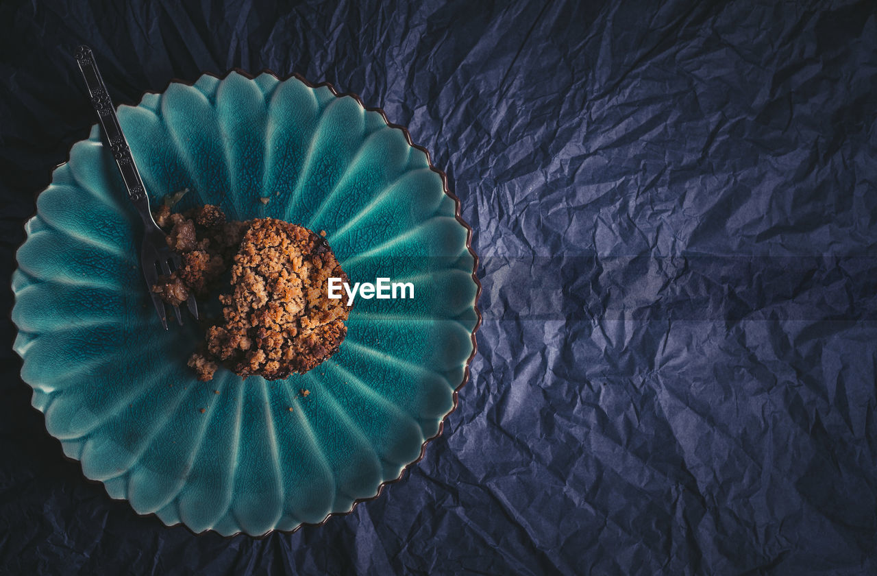 High angle view of apple pie on green plate on blue table